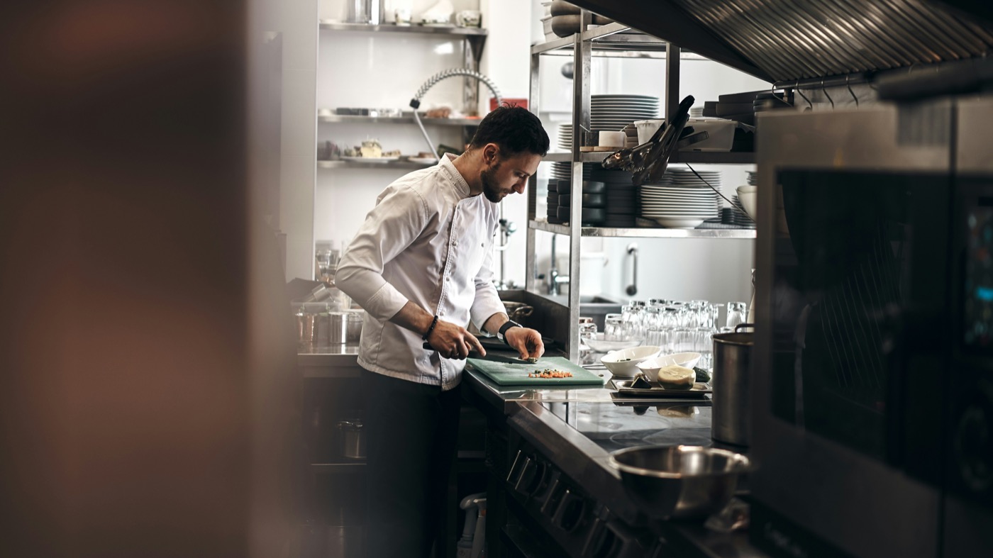 Chef préparant des plats dans une cuisine professionnelle propre et organisée